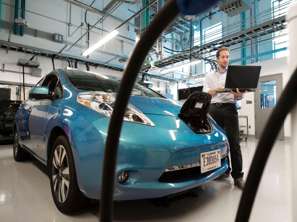 a person testing an electric car battery