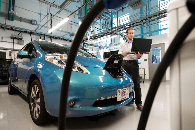 a person testing an electric car battery