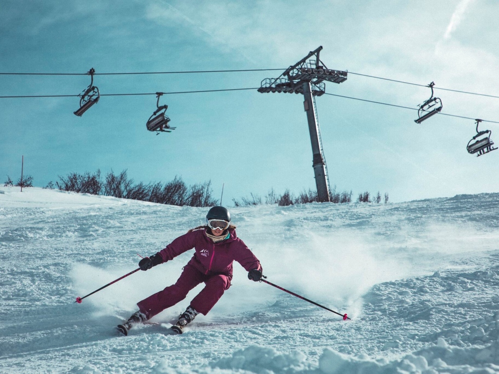 person skiing with a ski lift in the background