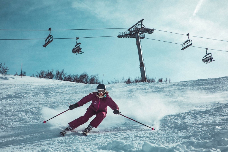 person skiing with a ski lift in the background