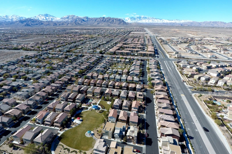 An aerial view of the Las Vegas sprawl with mountains in the background.